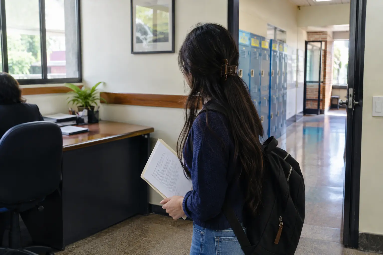 Estudiante de educación con una carta de autorización firmada en la rectoría de un colegio