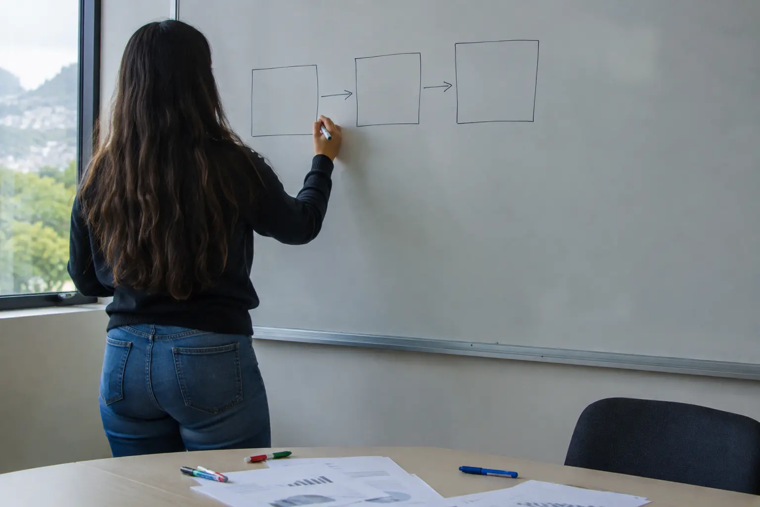Estudiante de mercadeo dibujando un modelo de tres predictores de la intención de compra