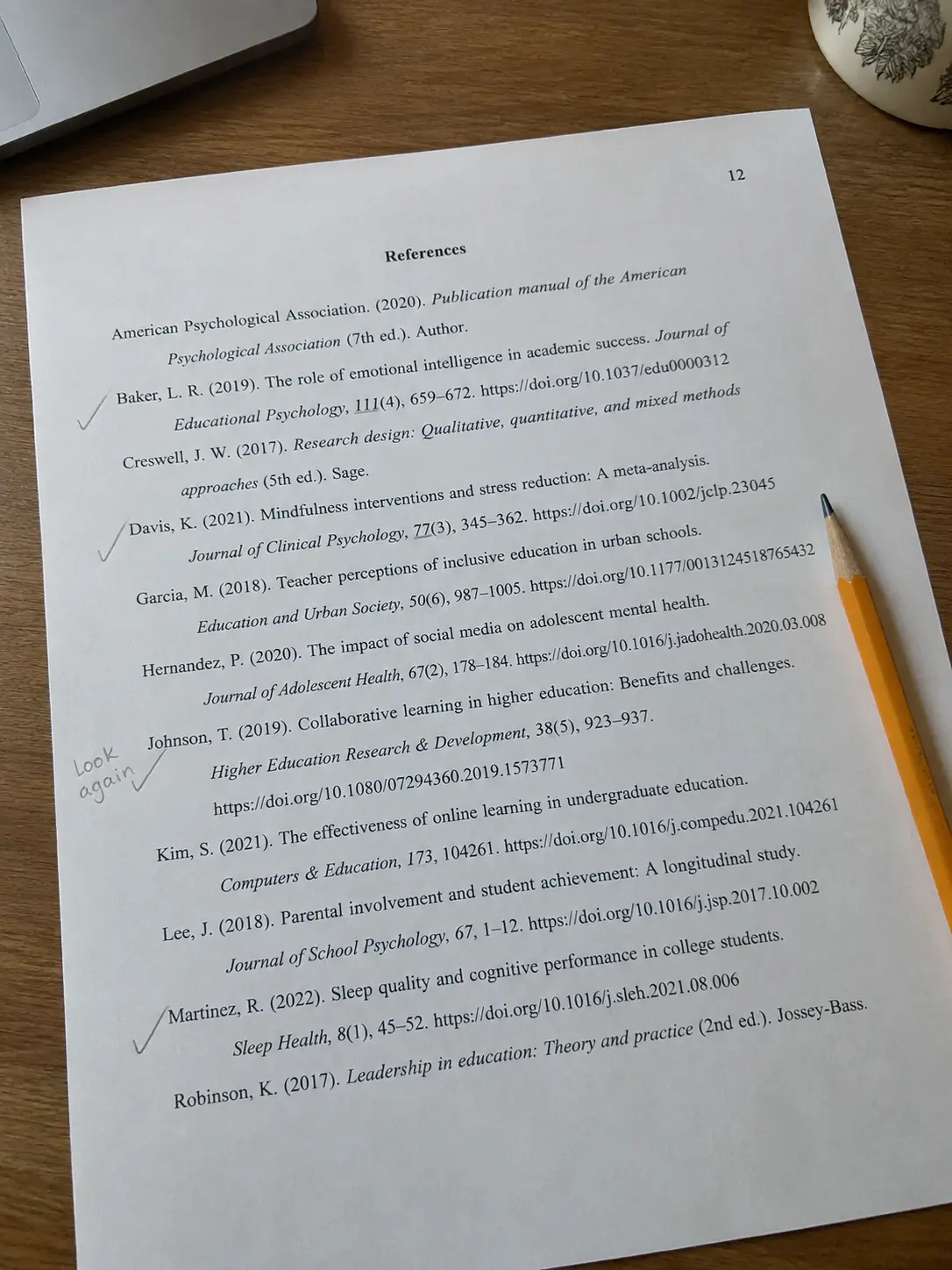 Lista de referencias impresa con sangría francesa y un lápiz marcando entradas